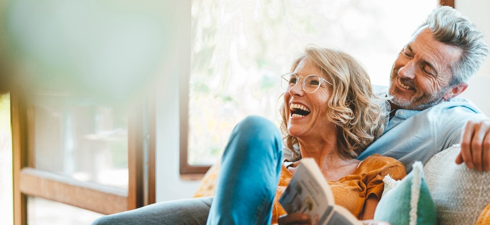 Two ladies sitting next to each other laughing